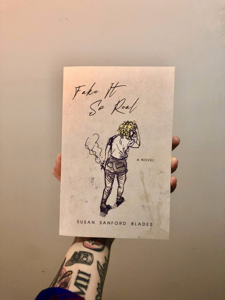 susan sand ford blade's book fake it so real being held by an arm